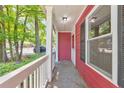 Covered front porch area with red siding, white railing, and black shutters, offering a quaint outdoor space at 350 Pleasant Oak Sw Ct, Marietta, GA 30008