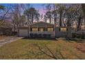 Charming single-story home at dusk, featuring a welcoming front porch and cozy curb appeal at 1602 Sycamore Nw Dr, Kennesaw, GA 30152