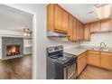 This modern kitchen features wood cabinets and black appliances, along with a fireplace in the adjacent room at 1602 Sycamore Nw Dr, Kennesaw, GA 30152