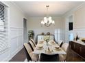 Elegant dining room with wainscoting, modern chandelier, and stylish furnishings at 3394 Bryerstone Se Cir, Smyrna, GA 30080