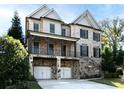 Charming two-story brick home with a stone foundation, a covered porch, and a two-car garage at 3394 Bryerstone Se Cir, Smyrna, GA 30080