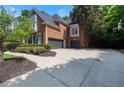 A brick two-story home featuring a two-car garage and a basketball hoop. It has a manicured lawn and paved driveway at 4567 Brigade Ne Ct, Roswell, GA 30075