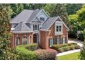 Attractive two-story home featuring a brick facade, dormer windows, and mature landscaping at 4567 Brigade Ne Ct, Roswell, GA 30075