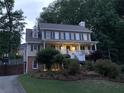 Two-story home with a welcoming front porch, lush landscaping, and a driveway leading to the side of the house at 1935 Shrader Ct, Lawrenceville, GA 30044