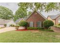 This property features a brick exterior, lush green lawn, and carefully manicured landscaping for great curb appeal at 4565 English Oaks Ln, Lilburn, GA 30047