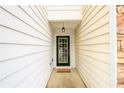 A close-up of the front door with a welcome mat, side light, and hanging light fixture at 559 Woodland Park Ter, Lawrenceville, GA 30043