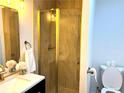 Bathroom features a modern glass-enclosed shower with gold hardware and bright vanity area at 877 Verona Dr, Clarkston, GA 30021