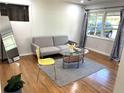 Bright living room with hardwood floors, a gray sofa, and a large window at 877 Verona Dr, Clarkston, GA 30021