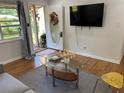 Cozy living room with hardwood floors, TV, modern furniture, and a view of the front yard at 877 Verona Dr, Clarkston, GA 30021