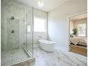 Bright bathroom showcasing a modern tub, glass shower, and marble floors at 1826 Terry Mill Se Rd, Atlanta, GA 30316