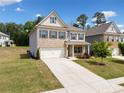 Inviting two-story home showcasing a mix of brick and siding, a neat lawn, and an attached two-car garage at 3360 Meadow Grass Dr, Dacula, GA 30019