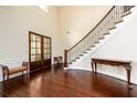 Grand foyer featuring dark wood floors, staircase with iron railings, and wainscoting at 6110 Read Rd, Suwanee, GA 30024