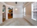 Dining room with modern light fixture, wainscoting, and large windows offering plenty of natural light at 4087 Kingsley Park Ct, Peachtree Corners, GA 30096