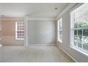 Bright living room with wainscoting, crown molding, and large windows creating a cozy atmosphere at 4087 Kingsley Park Ct, Peachtree Corners, GA 30096