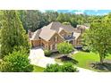 Stunning aerial view of a brick home with lush green lawn and mature trees, offering great curb appeal at 13037 Overlook Pass, Roswell, GA 30075