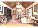 Cozy living room featuring a vaulted wood ceiling, fireplace, and built-in bookshelves at 13037 Overlook Pass, Roswell, GA 30075