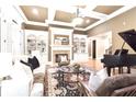Elegant living room with coffered ceiling, fireplace, built-in bookcases, and a grand piano at 13037 Overlook Pass, Roswell, GA 30075