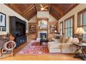 Inviting living room with vaulted wood ceiling, fireplace, built-ins, and wood floors at 13037 Overlook Pass, Roswell, GA 30075