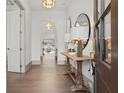 Bright foyer with hardwood floors, elegant lighting, console table, and arched doorways leading to other rooms at 375 Chattahoochee St, Roswell, GA 30075