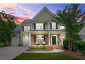 Charming two-story home with brick accents, covered porch and manicured lawn, at sunset at 1037 Panoramic Pte, Buford, GA 30518