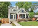Charming home with a red door, dormer windows and a well-manicured lawn with a wooden fence at 1393 Westview Sw Dr, Atlanta, GA 30310