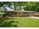Charming brick home with a well-manicured lawn, mature trees, and a classic design at 3060 Wilson Rd, Decatur, GA 30033