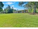 Expansive front yard showcasing a charming brick home with a lush green lawn and mature trees at 4129 Pepperdine Dr, Decatur, GA 30034