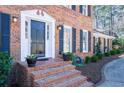 The front entrance shows a traditional brick staircase leading to a black front door with white trim at 725 Glengary Ne Way, Atlanta, GA 30342