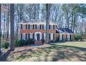 The front exterior features a classic brick facade, complemented by a well-manicured lawn and beautiful, mature trees at 725 Glengary Ne Way, Atlanta, GA 30342
