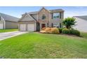 Traditional home featuring stone accents, manicured lawn, and attached two-car garage at 3235 Northcliff Dr, Suwanee, GA 30024