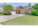 Beautiful home exterior with a manicured lawn, mature landscaping, and a three-car garage at 2041 Democracy Dr, Buford, GA 30519