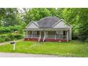 Quaint one-story home featuring a cozy front porch and a well-maintained lawn at 232 S Candler St, Villa Rica, GA 30180