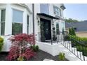 Inviting front entrance with brick steps, black railing, and a covered black awning, adding charm to the facade at 310 Hillpine Dr, Woodstock, GA 30189