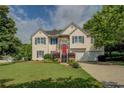 Charming two-story home with a well-manicured lawn and a pop of color from the red front door at 3870 Michaels Creek Ct, Loganville, GA 30052