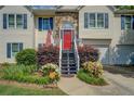 Inviting front entrance with a red door, blue stairs, and a beautiful landscaped garden at 3870 Michaels Creek Ct, Loganville, GA 30052