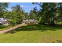 Inviting ranch home with a spacious front yard and mature trees, offering a serene suburban setting with a long driveway at 261 Township Dr, Hiram, GA 30141