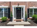 Elegant front entry with a black door, white trim, and manicured landscaping at 3174 Vickery Ne Dr, Marietta, GA 30066