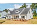 An eye-catching house features a lush yard, a concrete driveway, and a welcoming front porch at 1471 Stephens View Dr, Loganville, GA 30052