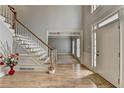 Bright foyer with hardwood floors and staircase and views to the living room beyond at 340 Kincardine Way, Alpharetta, GA 30022