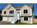 Beige two-story house with staircase leading to the front door, white trim, and an attached two-car garage at 102 Peaceful Vw, Acworth, GA 30102