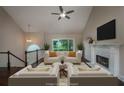 Cozy living room with fireplace, ceiling fan, and serene view of the outdoors at 102 Peaceful Vw, Acworth, GA 30102