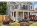 Inviting front porch with white columns, charming landscaping, and decorative arbor at 111 Jeffrey Pl, Smyrna, GA 30082