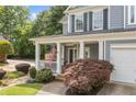 Charming home featuring a covered porch, an American flag, and lush landscaping at 111 Jeffrey Pl, Smyrna, GA 30082