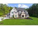 Elegant two-story home with a mix of stone and painted brick, complemented by a vibrant green lawn at 2400 Worth Ave, Loganville, GA 30052