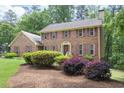 Charming brick home with lush landscaping including bushes and vibrant plants at 2101 Breconridge Sw Dr, Marietta, GA 30064