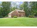 A classic brick home with a two-car garage and a spacious front yard, nestled amongst mature trees at 2101 Breconridge Sw Dr, Marietta, GA 30064