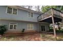 Two-story home showcasing a deck on the second story with sliding glass doors at 345 Deerwood Dr, Suwanee, GA 30024
