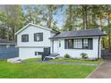Charming split-level home with white exterior, black shutters, and well-manicured lawn at 6864 Maddox Rd, Morrow, GA 30260
