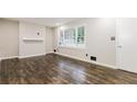 Bright living room featuring hardwood floors, fresh paint, and a large window at 6864 Maddox Rd, Morrow, GA 30260