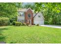 Traditional two-story home with brick accents and a well-manicured lawn, surrounded by trees at 190 Crestworth Ct, Powder Springs, GA 30127